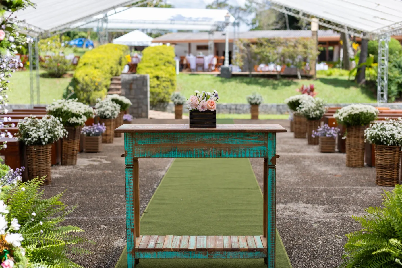 Corredor de cerimônia com decoração rústica e arranjos florais - Nuestra Fiesta Atibaia