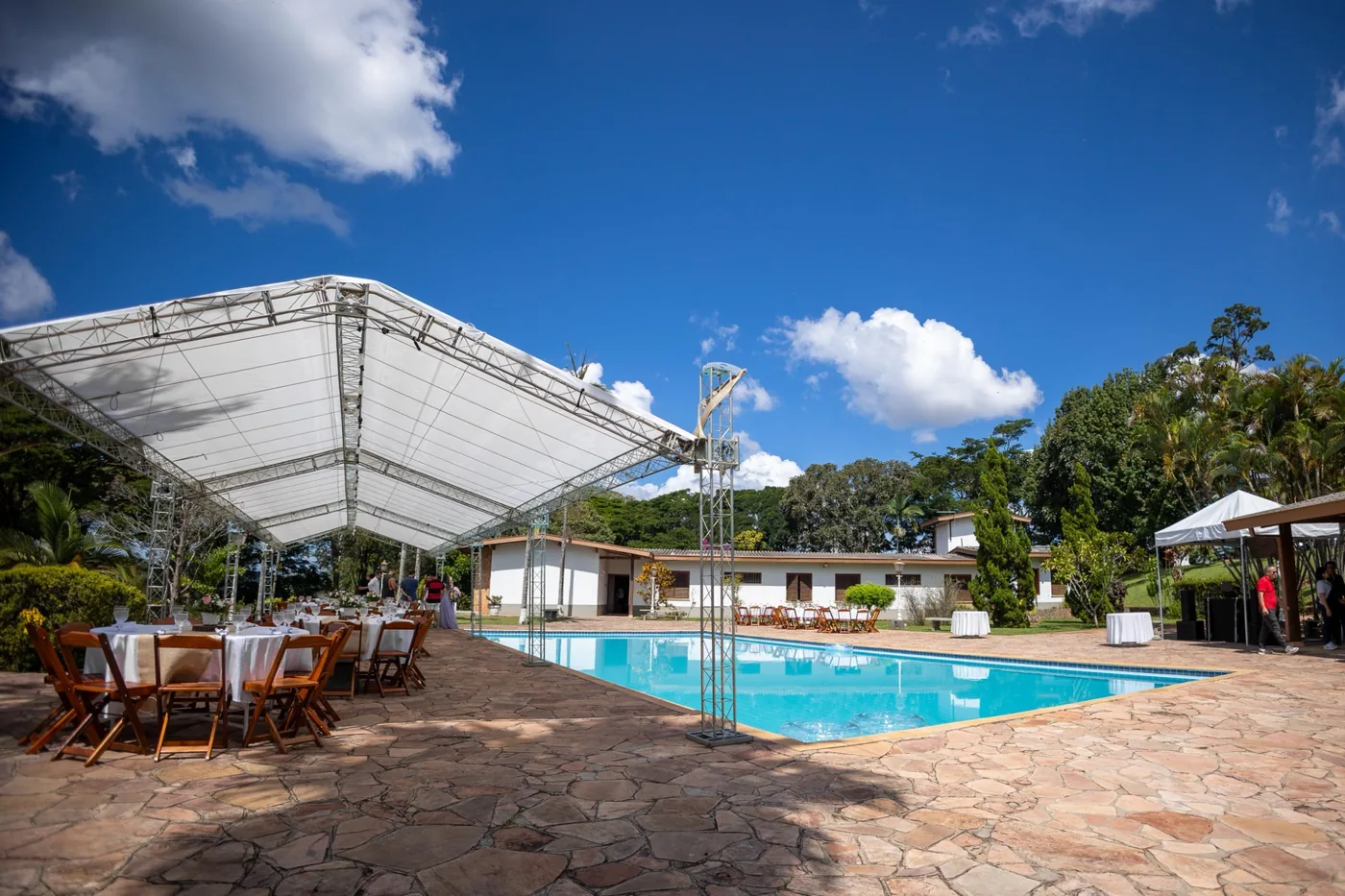 Tenda Box Truss ao lado da piscina com mesas e cadeiras para evento - Nuestra Fiesta Atibaia